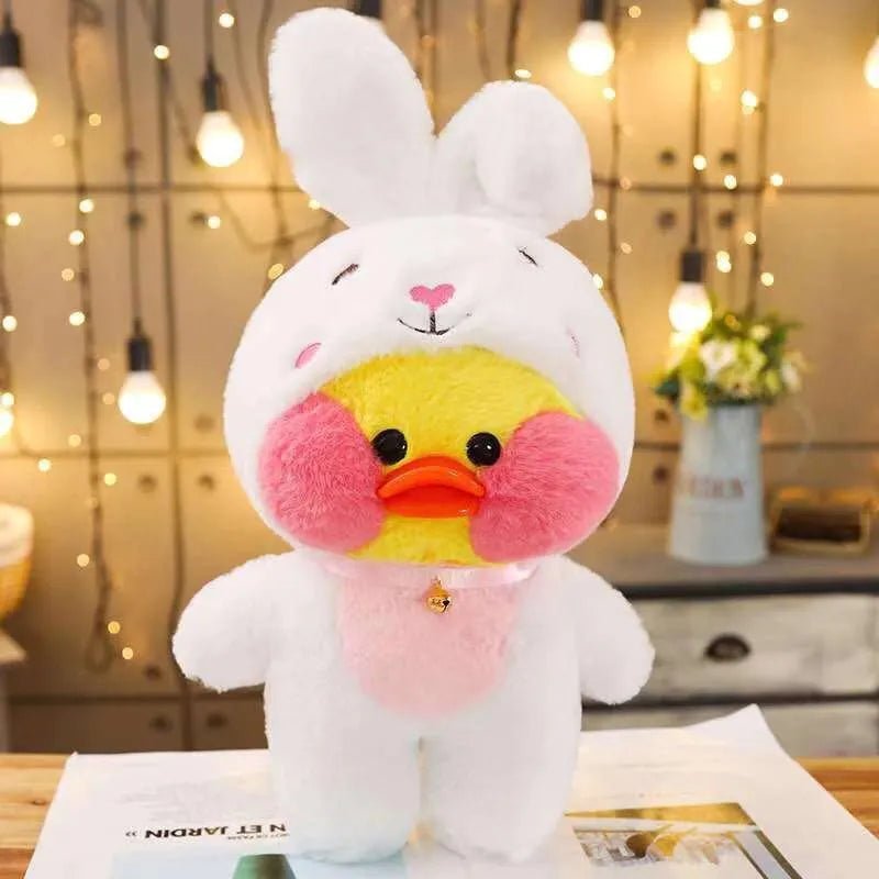 Plush toy with a rabbit and duck face design on a table with a blurred background