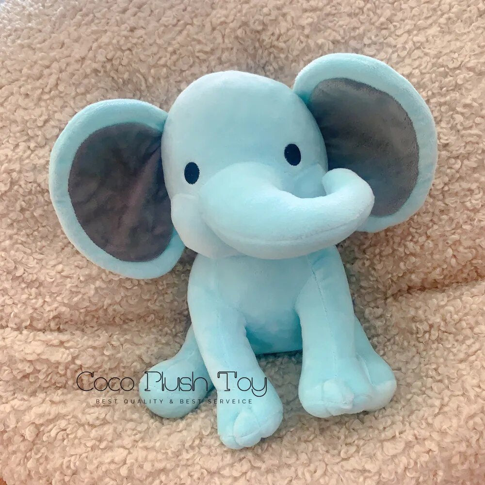 Blue elephant plush toy on a beige surface with 'Coco Plush Toy' branding.