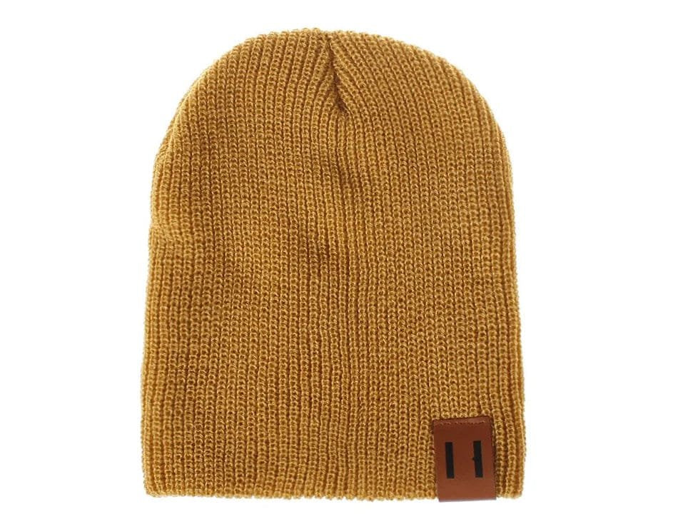 Mustard yellow knit beanie with a brown leather patch on a white background