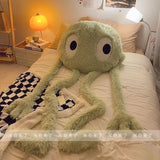 Large green plush toy on a bed in a bedroom setting