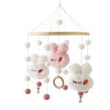Plush toy mobile with bunnies and white balls on a white background
