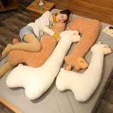Person lying on a bed with large, U-shaped plush toys.