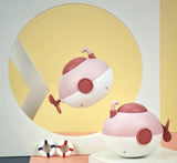 Two pink and white robot toys on a light background
