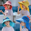 Four children wearing colorful sunhats by a pool.