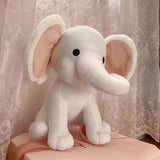 Plush elephant toy with pink accents on a floral curtain background