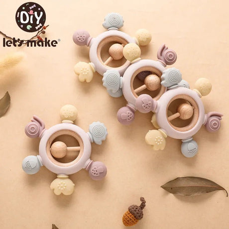 Colorful baby teething rings with 'let's make' branding on a beige background
