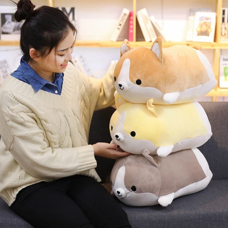Person holding a plush toy shaped like a dog with a yellow body and brown legs on a couch.