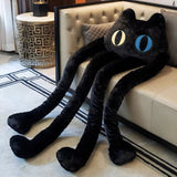 Black plush toy resembling a cat on a white couch in a living room setting.