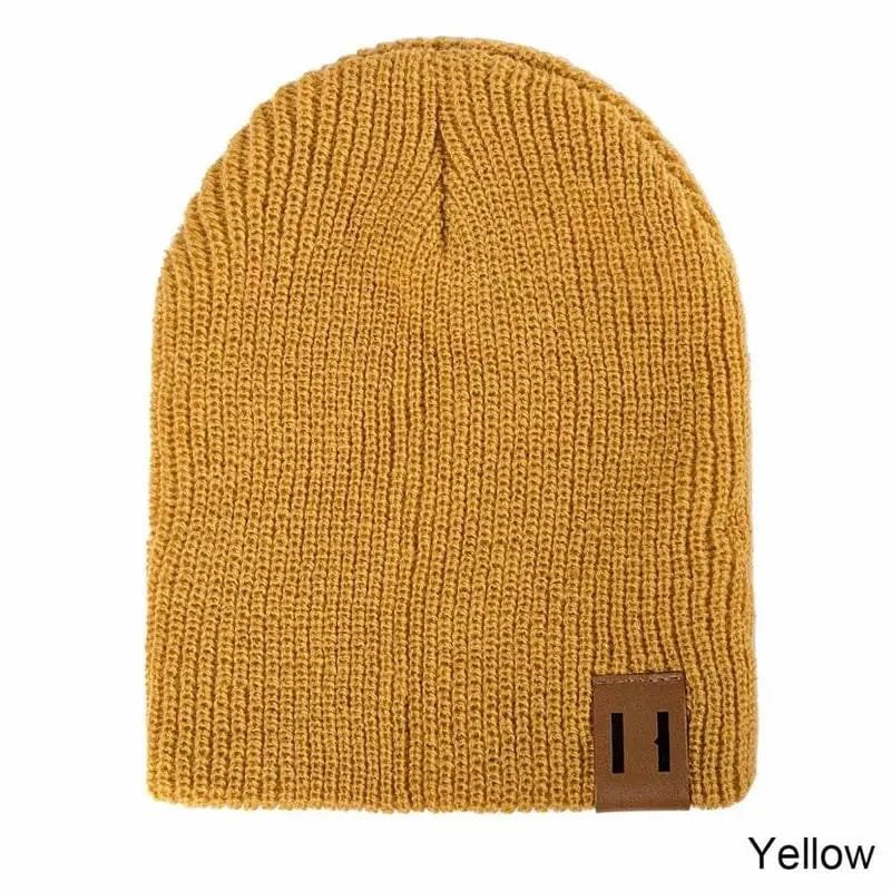 Yellow knit beanie with a brown patch on a white background