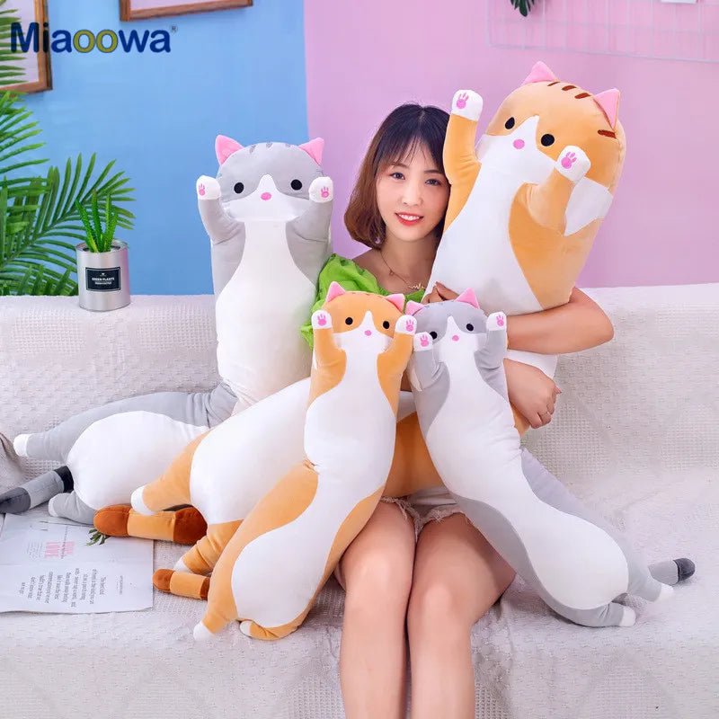 Woman holding large cat-shaped plush toys with 'Miaowa' branding in a home setting.