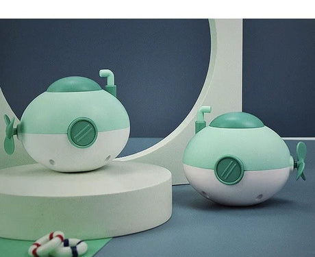 Two green and white toy submarines on a blue and gray background