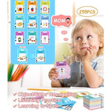 Child holding a flashcard with 'MOM' and educational cards on a table.