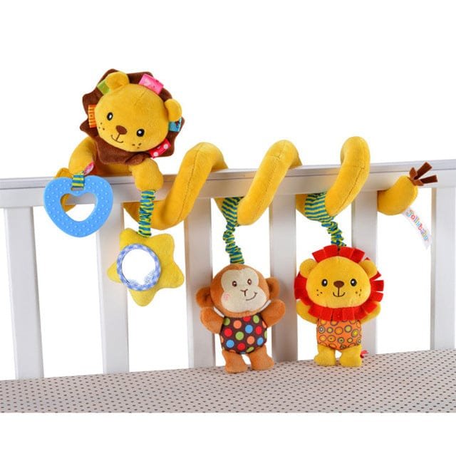 Colorful lion and monkey crib toys hanging from a crib rail.
