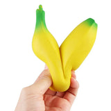 Hand holding a yellow banana-shaped stress reliever toy against a white background