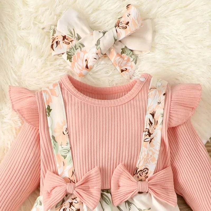 Pink ribbed sweater with floral suspenders and matching headband on a soft white background