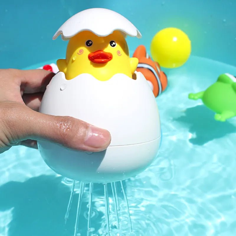 Yellow duck toy in an eggshell held over a pool with water splashing out