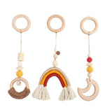 Three wooden baby rattle toys with colorful beads and tassels on a white background