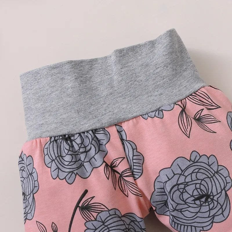 Pink pants with floral pattern and gray waistband on a light background