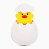 Yellow rubber duck in a white egg壳 on a white background
