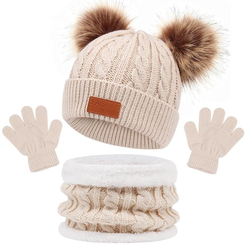 Knitted hat with pom-poms, gloves, and scarf set on a white background