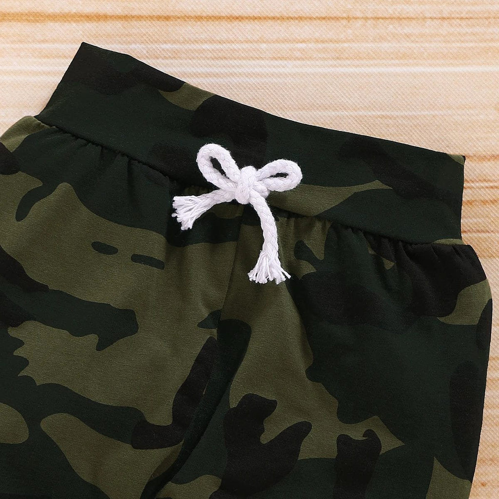 Camouflage shorts with a white drawstring on a wooden surface