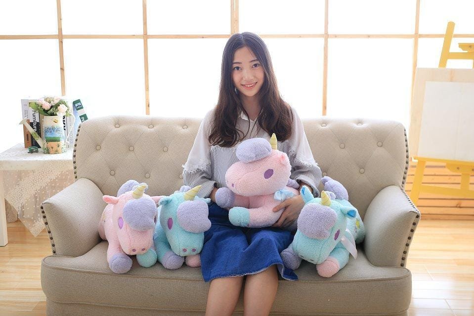 Woman sitting on a couch with colorful unicorn plush toys