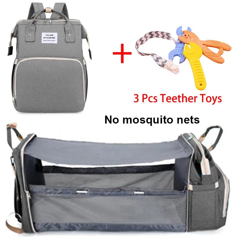 Gray backpack with baby accessories including a crib and teether toys.