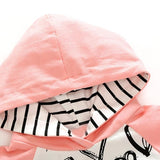 Pink hooded blanket with a black and white pattern underneath
