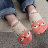 Children's socks with fox design worn by a child in jeans.