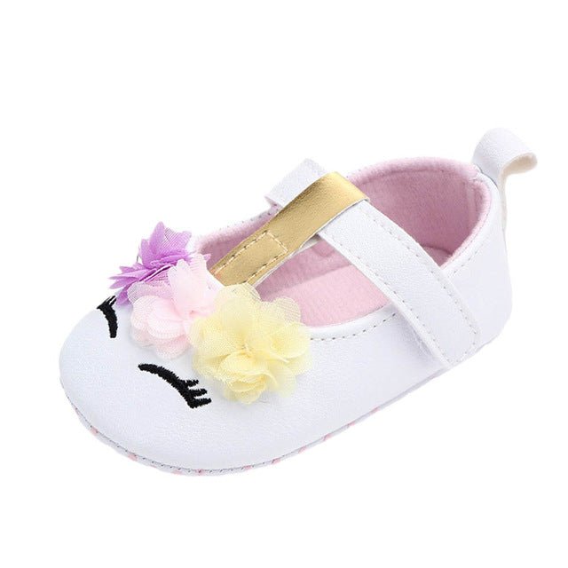 White baby shoe with floral design and gold buckle