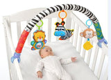 Baby lying in a crib with colorful baby gym toys hanging above