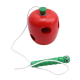 Red bird feeder with a green caterpillar toy.