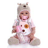 Baby doll in a bear costume holding a pink bottle.