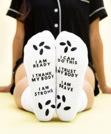White socks with motivational text worn by a person.