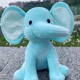 Blue elephant plush toy sitting on a concrete surface