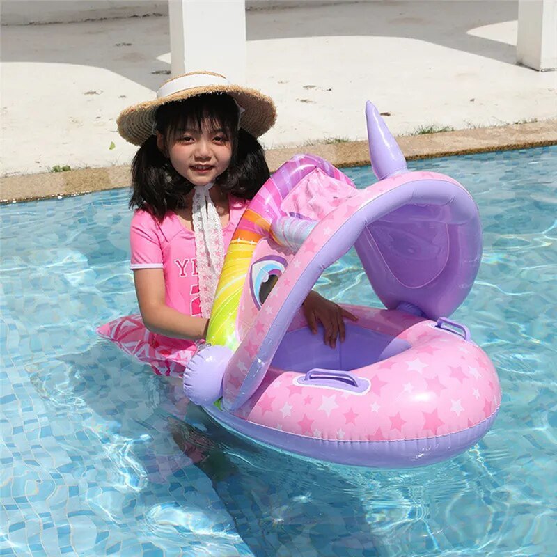 Child in a pool with a pink inflatable seat and rainbow design