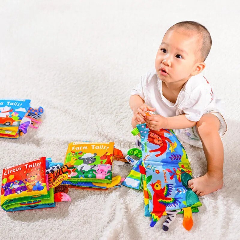 Child playing with colorful books and a soft toy on a white surface