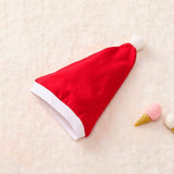 Red Santa hat on a light beige surface with decorative items.