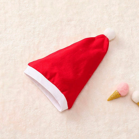 Red Santa hat on a light beige surface with decorative items.