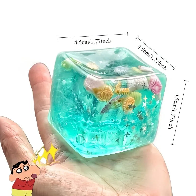Transparent cube with underwater-themed filler held in a hand, with measurements indicated.
