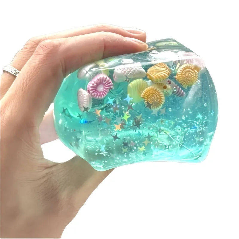 Hand holding a clear blue slime with sea-themed decorations