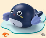 Navy blue whale-shaped bath toy with purple fins.