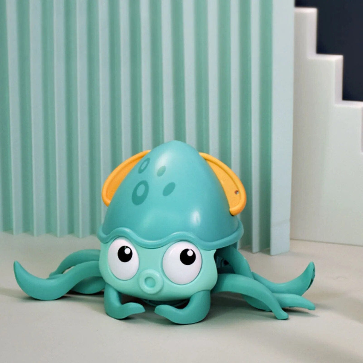 Toy octopus with a yellow hat on a light surface
