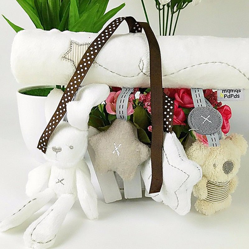 Decorative items, including a plush elephant, a star, and a bear, on a white surface with flowers.