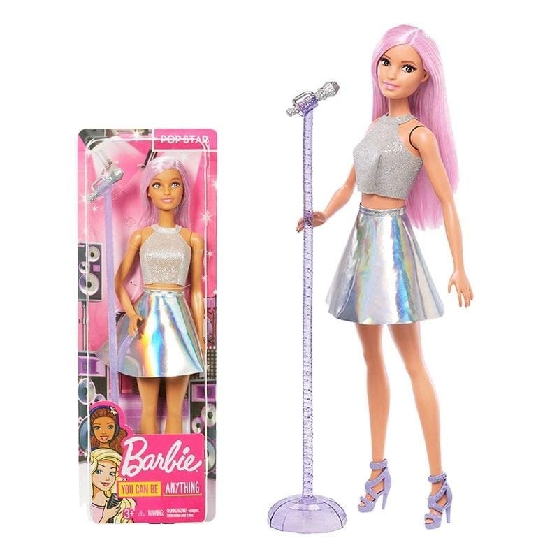 Barbie doll with pink hair and silver outfit next to its packaging