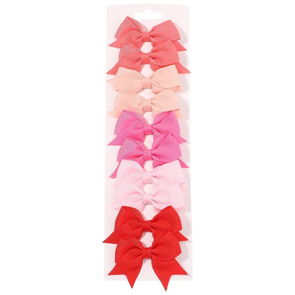 Set of colorful hair bows in a white packaging on a white background