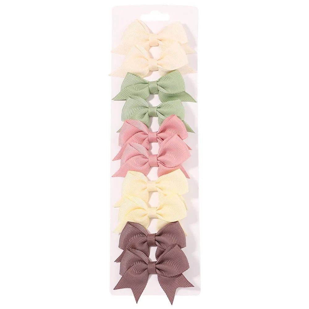 Set of five colorful hair bows in a clear packaging on a white background