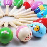 Colorful wooden rattles with cartoon faces.