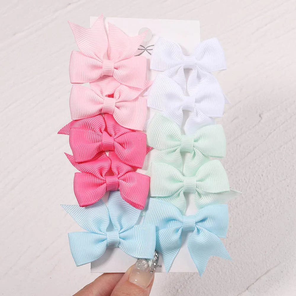 Set of colorful hair bows on a textured white background