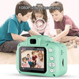 Children playing with a green toy camera displaying a video on its screen.